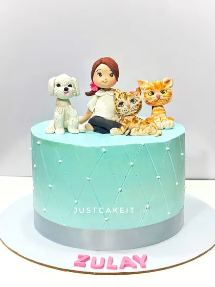 An adorable cake for a girl who loves her pets. The design features a custom edible figurine of her with her dog and two cats.