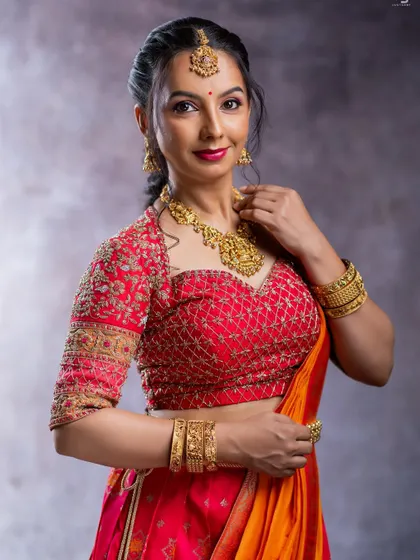 A vibrant red blouse with a sweetheart neckline and detailed gold threadwork. This piece is a stunning choice for brides and is available for rent for your big day.