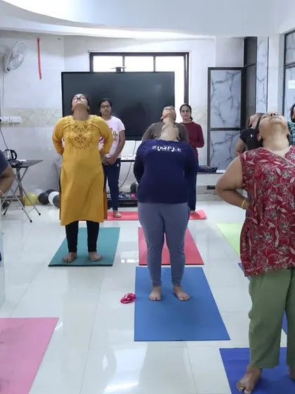 Participants in our free yoga camp practice a gentle neck and shoulder stretch. These warm-ups are essential for preparing the body for asana practice and releasing everyday tension.