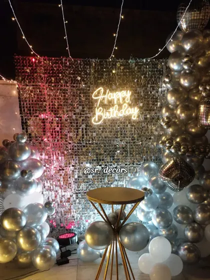 The shimmer wall reflects the party lights, adding energy and sparkle to this outdoor birthday setup.
