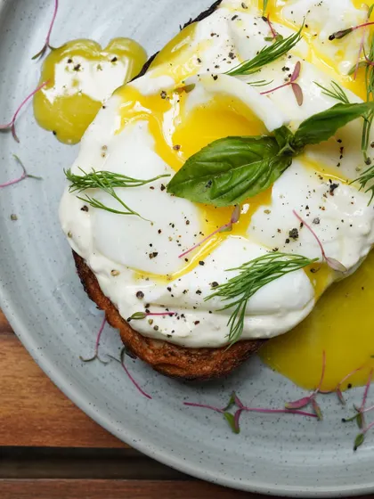 A perfectly poached egg with a runny yolk over our house-made cheese on a slice of toasted sourdough. It's simple, elegant, and incredibly delicious.
