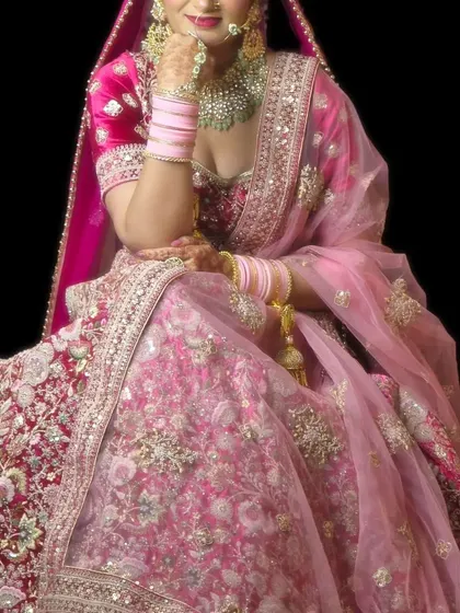 This bride is wearing a beautiful Polki set paired with a vibrant pink lehenga. The jewellery is designed to complement the heavy embroidery of the outfit.