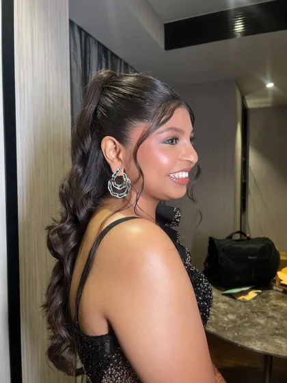 A profile view of the bride, her happy smile and glamorous ponytail creating a picture-perfect reception look.