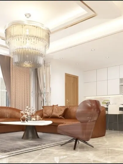 An open-plan living and kitchen area in the Pune villa. A rich brown leather sofa complements the sleek, modern kitchen island, creating a cohesive and stylish space for living and entertaining.