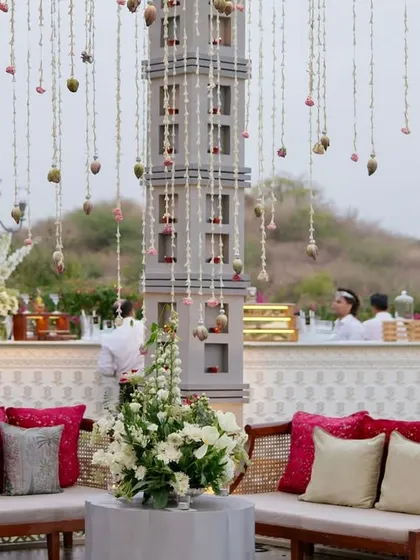 A daytime event in Udaipur featuring thousands of suspended floral strings, creating a magical, swaying canopy over the guest seating and bar areas.