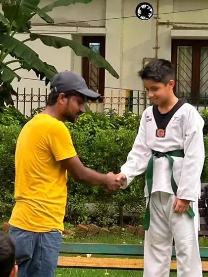 A handshake of congratulations during a color belt ceremony. Recognizing progress is an important part of building a student's confidence.