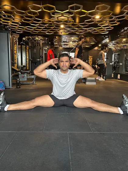 Flexibility is just as important as strength. This member is demonstrating incredible flexibility with a full split, a result of consistent stretching and dedication to all aspects of fitness.