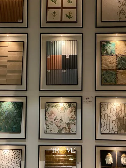This wall of framed tiles acts as a design library. It showcases a variety of styles you can mix and match, from floral and geometric patterns to textured and multi-toned tiles, helping you find the perfect combination.