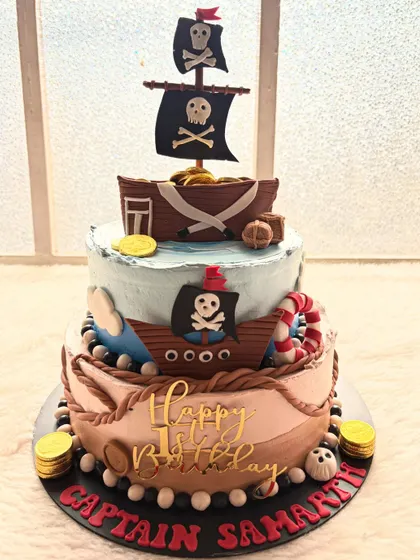 Ahoy, matey! A three-tier pirate ship cake ready for a treasure hunt. This cake is perfect for an adventurous birthday party.