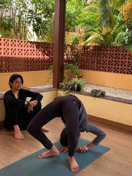 The Wheel Pose, or Chakrasana, is a deep backbend. I closely supervise and support my students as they explore this posture, ensuring they practice safely while working on their spinal flexibility and strength.
