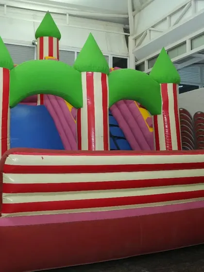A large bouncy castle set up indoors for a party. This is a fantastic way for kids to burn off energy and have a blast, regardless of the weather outside.