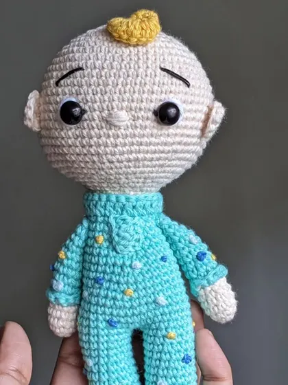 Holding the JJ doll to show its scale and soft, huggable form.