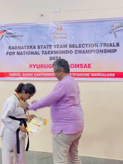 A student receives her medal at the Karnataka State Team Selection Trials. Each medal represents countless hours of practice, discipline, and the spirit of a true martial artist.