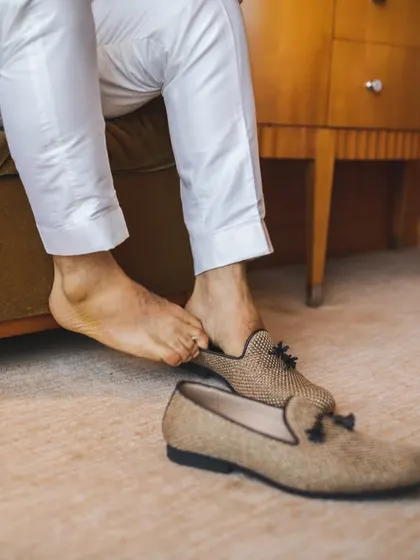 A detail shot of the groom putting on his traditional 'mojari' shoes. We believe every part of the getting ready process is part of the story.