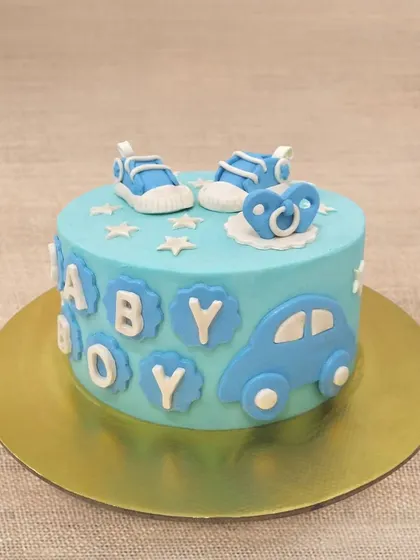 We welcome a baby boy with this charming and classic blue-themed cake. Adorned with baby shoes, a pacifier, and a toy car, this cake is a sweet and simple way to celebrate the arrival of a little one.