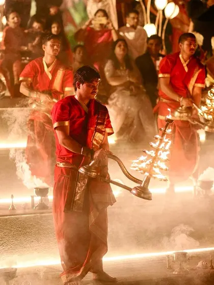 A beautiful moment from a traditional Ganga Aarti ceremony incorporated into the wedding festivities, with priests holding ornate lamps.
