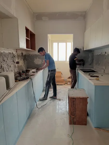 Teamwork makes the dream work, especially in a kitchen renovation. Our crew is seen here working on the countertops and cabinets for a new, modern kitchen.