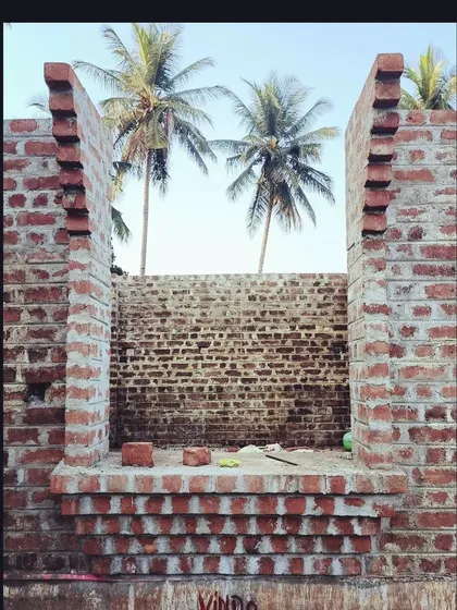 Construction in progress at the Samyak Yoga retreat. The air is filled with the earthy smell of lime mortar as the brick walls rise, framed against the coconut trees. This is what building with natural, traditional materials feels like.