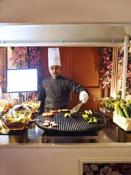 A chef at a live grill station, preparing fresh vegetables. This healthy and delicious option is perfect for corporate wellness events or as a lighter choice in a larger buffet.