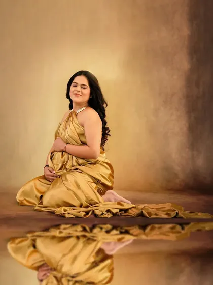 A creative portrait using a reflection to enhance the beauty of the golden satin drape.