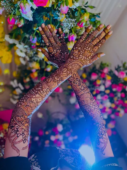 A dramatic shot of the bride's arms raised, showing the full extent of her beautiful bridal henna.