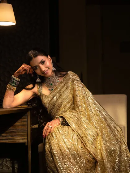 An artistic, moody shot that highlights the shimmer of the saree and the elegance of the makeup.