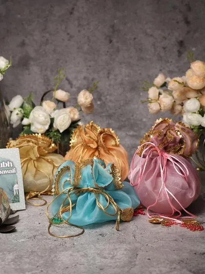 Our Diwali collection is perfect for corporate and personal gifting. This image shows our budget-friendly and customizable potlis, presented with elegant diyas and flowers for a classic festive look.