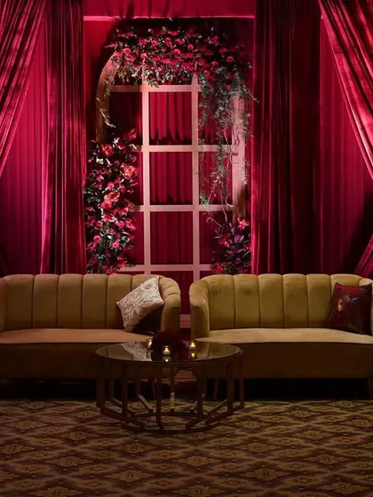 A guest lounge area designed for comfort and style. The warm tones of the yellow sofas provide a beautiful contrast to the deep red floral and fabric backdrop.