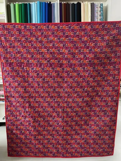 The back of a scrappy "trip around the world" quilt, showing a single, continuous pattern.