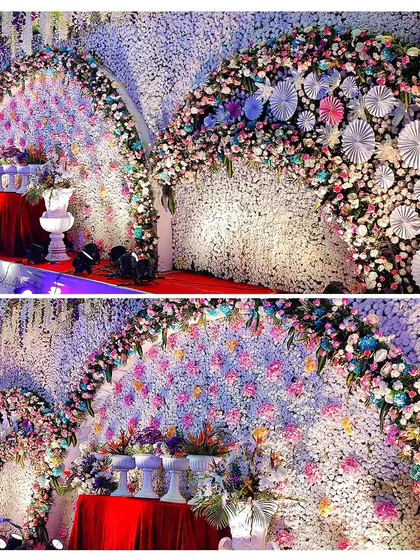 Another view of the stunning floral wall with paper fan details. The lighting highlights the craftsmanship and the vibrant colors used in this creative backdrop.