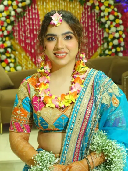 A beautiful Haldi look with the hair styled in a curly updo and adorned with floral jewelry, perfect for a bridal photoshoot.