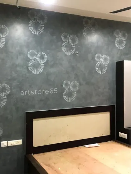 The finished modern accent wall in a bedroom setting. The placement of the stencils is customized to work with the room's furniture and layout, creating a cohesive interior design.