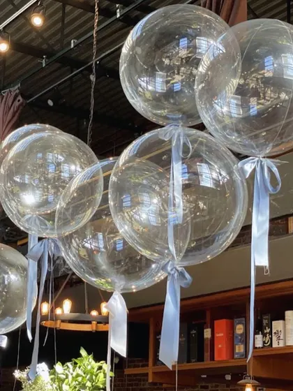 Sometimes, simplicity is key. These clear helium bobo balloons with simple blue ribbons were used to create a dreamy, ethereal vibe for a restaurant's decor.