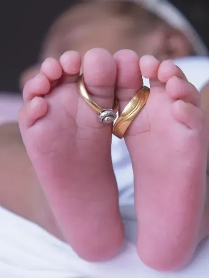 It's the tiny details that hold the biggest memories. A close-up of newborn feet with the parents' wedding rings tells a story of family and love in a single, powerful image.