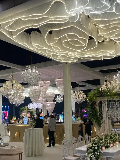 A wide shot showcasing the scale of a custom ceiling installation. The combination of the glowing fabric sculpture and dozens of crystal chandeliers demonstrates my team's ability to execute large-scale, complex production designs.
