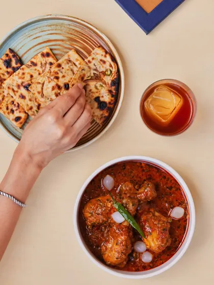 A classic chicken curry, with tender pieces of chicken simmered in a robust, onion-tomato gravy, paired with a simple naan.