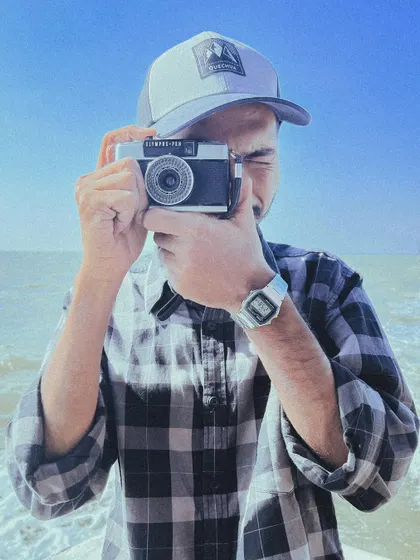 Me with a vintage film camera by the sea. Whether it's digital or analog, the love for capturing moments is the same.