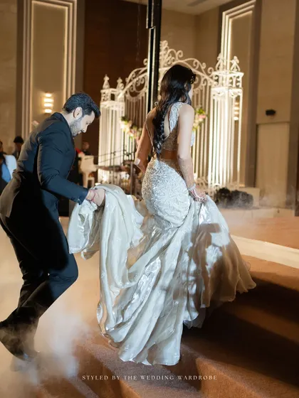 The groom helping his bride with her train, a moment of modern-day chivalry.