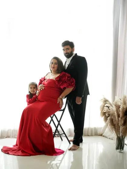 A formal studio portrait celebrating the next chapter. This maternity session captures the elegance and excitement of a growing family, with coordinated outfits creating a classic, polished look.