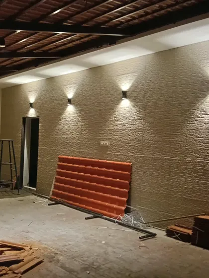 A work-in-progress shot of a textured wall finish. Here, we have already installed the up-and-down lighters that will graze the wall's surface, highlighting its unique texture once the project is complete.