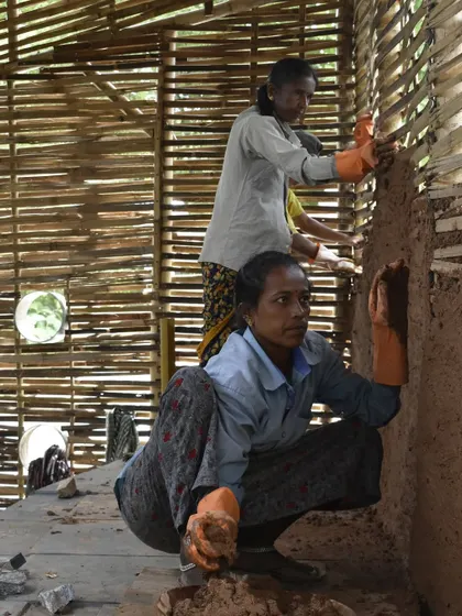 Two of our skilled masons applying daub to a bamboo wattle wall. Through our training, these women master sustainable building practices, gaining confidence and creating positive change in their communities.