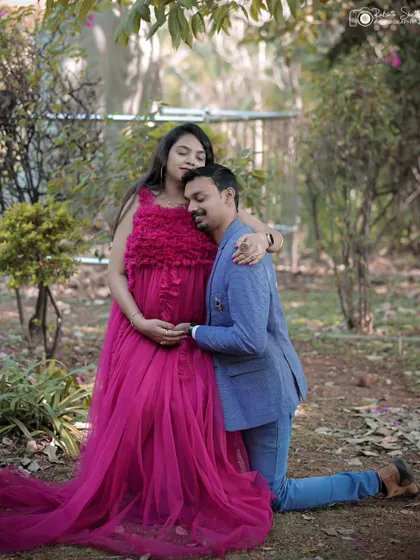 This pose beautifully captures the affection and support between the couple, with the lush garden providing a stunning backdrop for their maternity portraits.