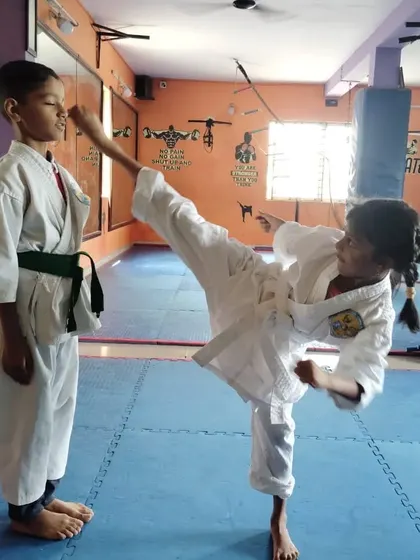 A young student practices a high kick with perfect form during a training session. This demonstrates the control and precision we teach.