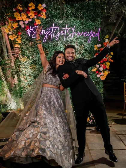 Pure celebration. This fun shot captures the energy of the sangeet night, with the couple looking ecstatic and the bride's outfit catching the light perfectly.
