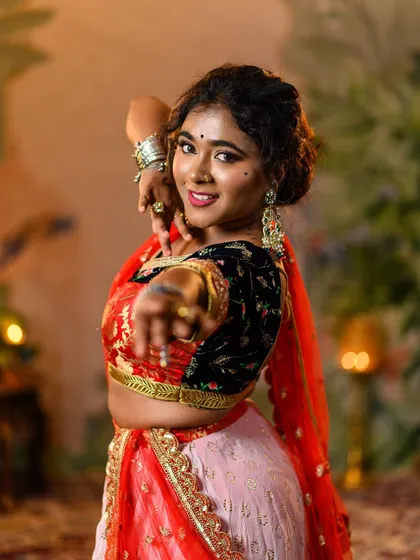 An engaging close-up where the model reaches towards the camera, inviting you into the story. This highlights the makeup, nose ring, and large statement earrings that are key to this look.