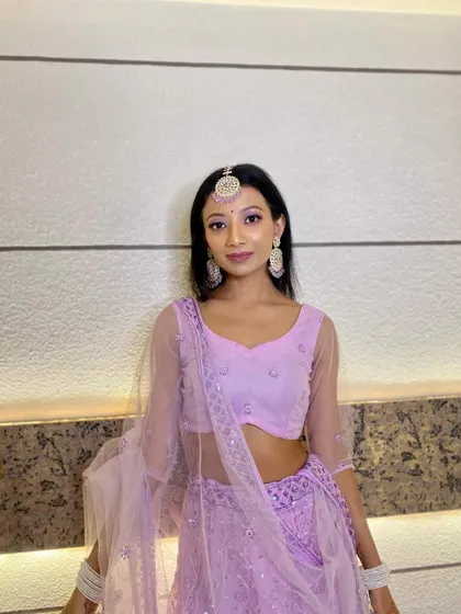A beautiful bridesmaid in a lavender lehenga. The makeup is soft and elegant, with a focus on lilac eyeshadow to match her outfit.