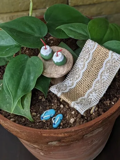 Cozy vibes with a miniature setup. This beach scene is a perfect escape, right in a planter pot.