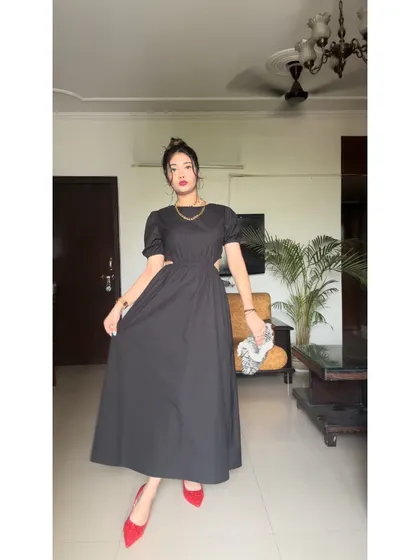 Another angle of this chic black dress. The puff sleeves add a touch of romance to the otherwise modern design.