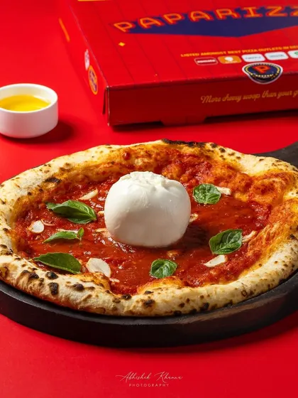 A Neapolitan-style Burrata pizza, photographed for Paparizza's online ordering platform. The lighting is designed to emphasize the fresh, creamy burrata and the perfectly baked crust, making it irresistible for delivery app users.