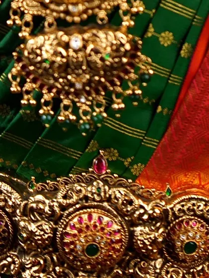 A detail shot focusing on the waist belt (oddiyanam) and the pendant of the long necklace. These traditional pieces are essential to a classic South Indian bridal look.